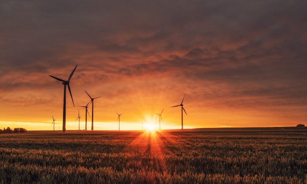 windmill on grass field during golden hour